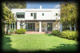 Irving Gill's Miltimore House, exterior color photo of white stucco house with terrace covered by wood pergola