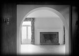 Irving Gill's Dodge House, a mid-century modern house. Black and white photo looking through deep arch in wall into the living room